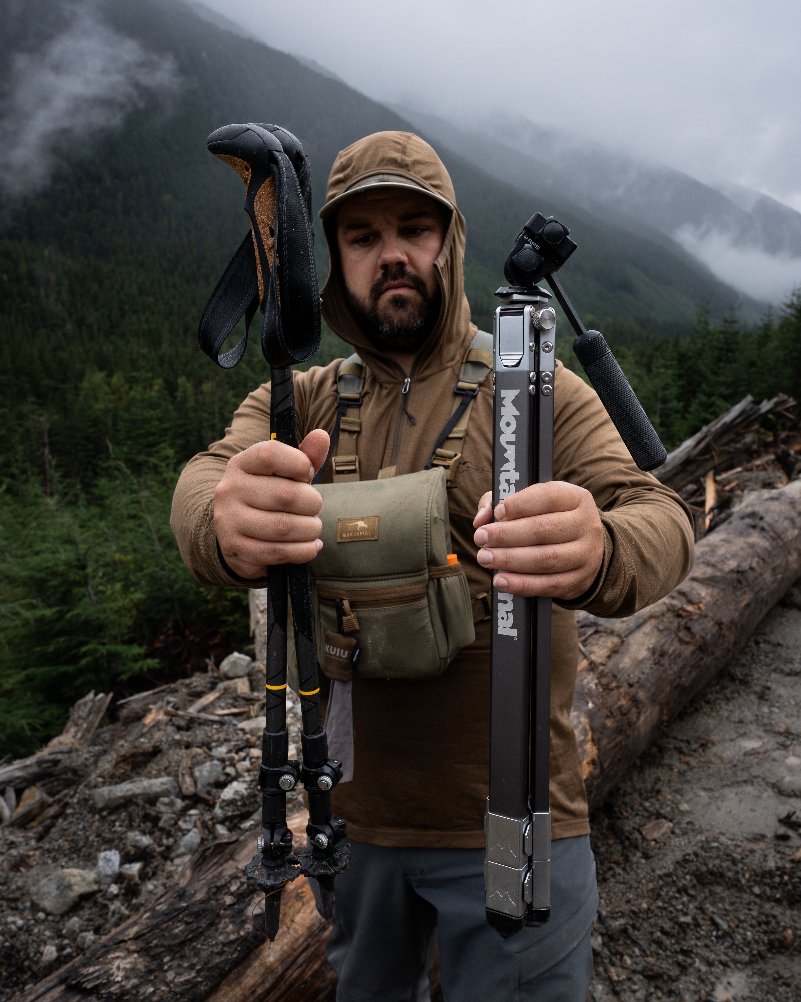 Hunter holds a pair of trekking poles next to the Mountain MInimal™, Talus™ 56 backcountry hunting tripod to show ultra compact size of tripod.
