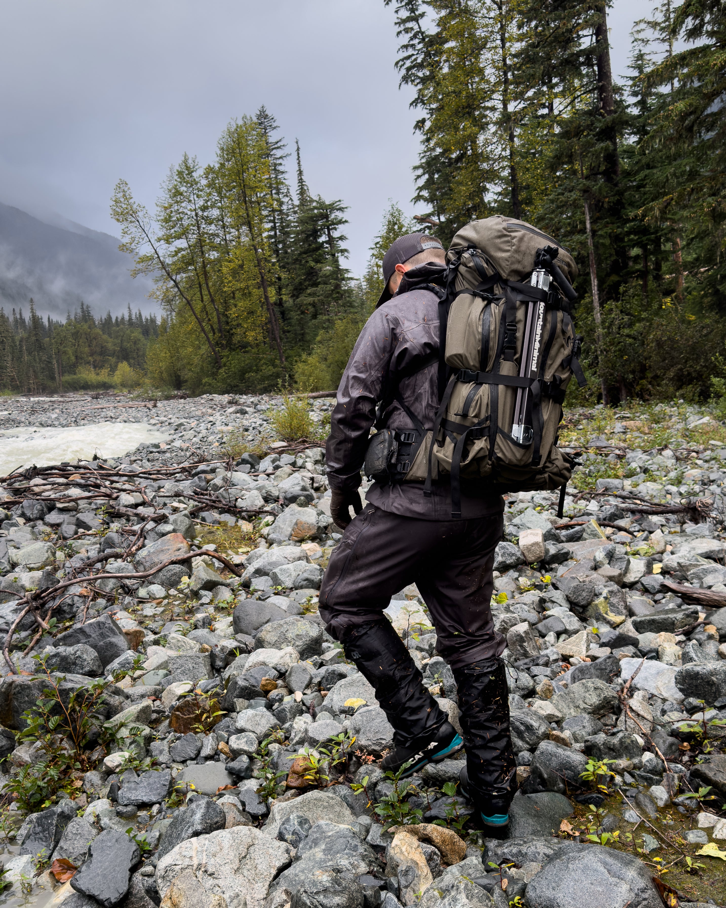 Hunter hiking with Mountain Minimal™ Talus™ 56 hunting tripod strapped on Stone Glacier backpack.