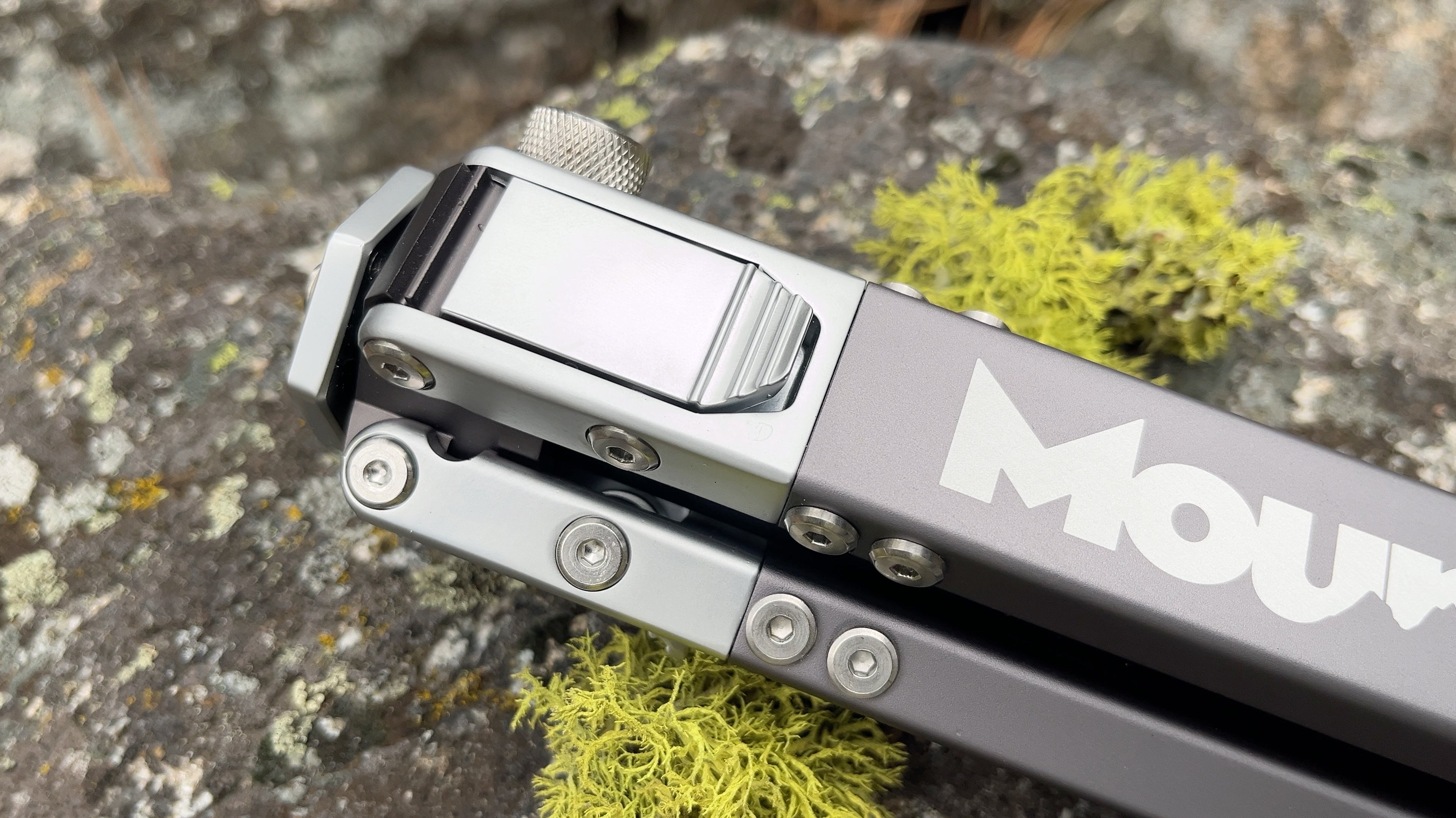 Detail shot of Mountain Minimal backcountry hunting tripod laying on rock with lychen.